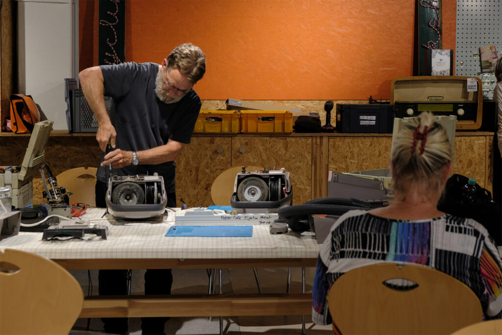 Harrald, a member of the repair café at the NochMall repairing a vacuum cleaner. © Max O'Dell